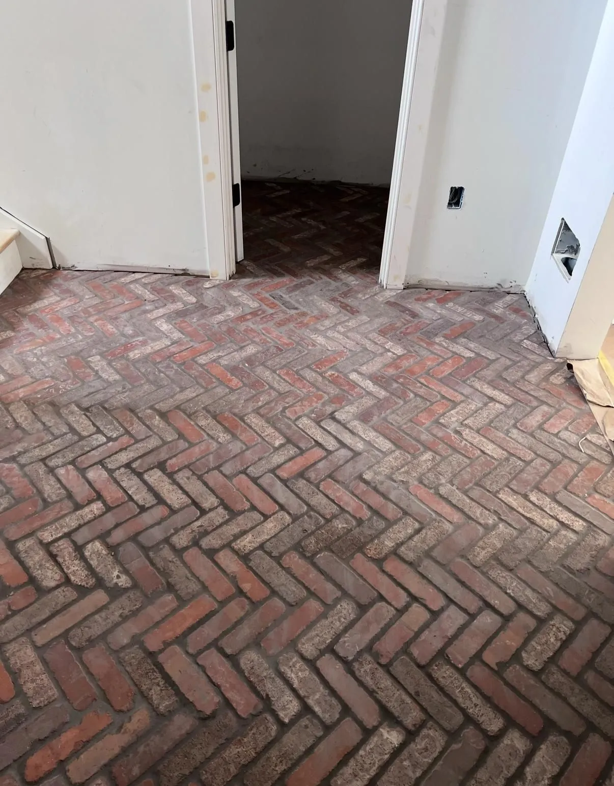 Brick herringbone floor tile installed by Hardwood Kings